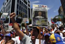 Opposition supporters shout during a rally against Venezuela's President Nicolas Maduro's government and in support of the political leaders in prison, in Caracas May 30, 2015. The banner with pictures of jailed political leaders Leopoldo Lopez and Daniel Ceballos reads, "Venezuela in solidarity with Leopoldo and Ceballos". The two opposition leaders were jailed a year ago for their roles in deadly protests against the government of socialist President Nicolas Maduro. REUTERS/Carlos Garcia Rawlins